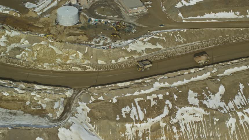 Dump trucks driving on a snowy dirt road