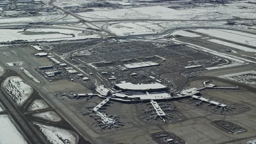 Aerial panorama of an airport with the surrounding area covered in snow