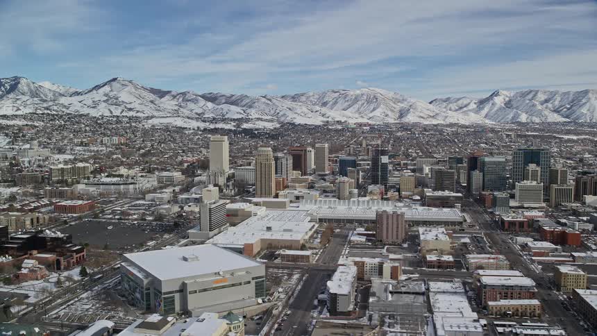 Aerial panorama of a metropolis surrounded by a chain of snowcovered mountains