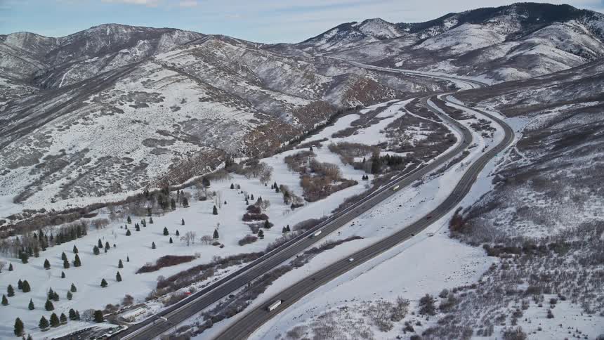 Aerial of the highway in a landscape of mountains during winter