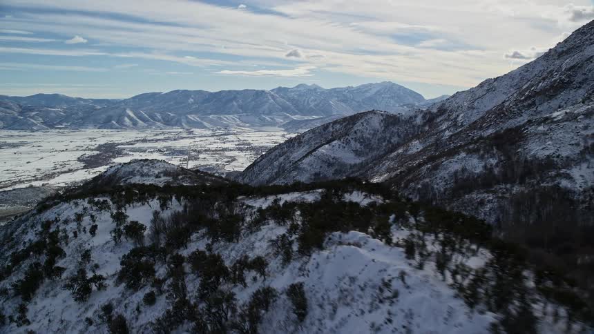 Aerial landscape of mountains with trees covered in snow on a morning