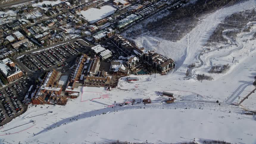Aerial of people snowboarding on a mountain in a resort