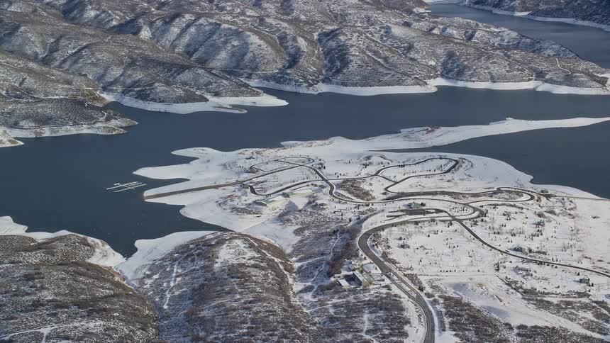Aerial panorama of snowcovered hills and mountain slopes by a lake