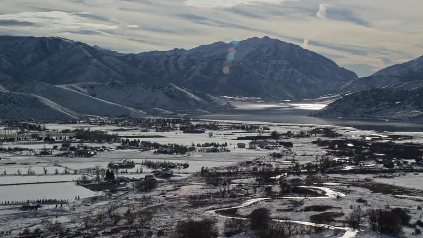 Snow covers the ground of a rural area surrounded by tall mountains