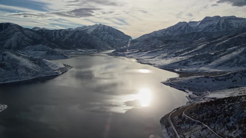 Aerial of a lake surrounded by mountains during dawn
