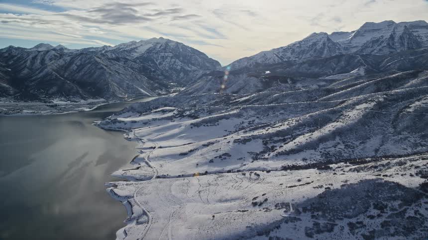 Aerial view of a lake next to the snowy mountains