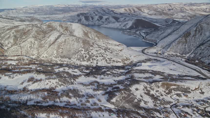 Aerial of the valley with a small town between hills and lakes during winter