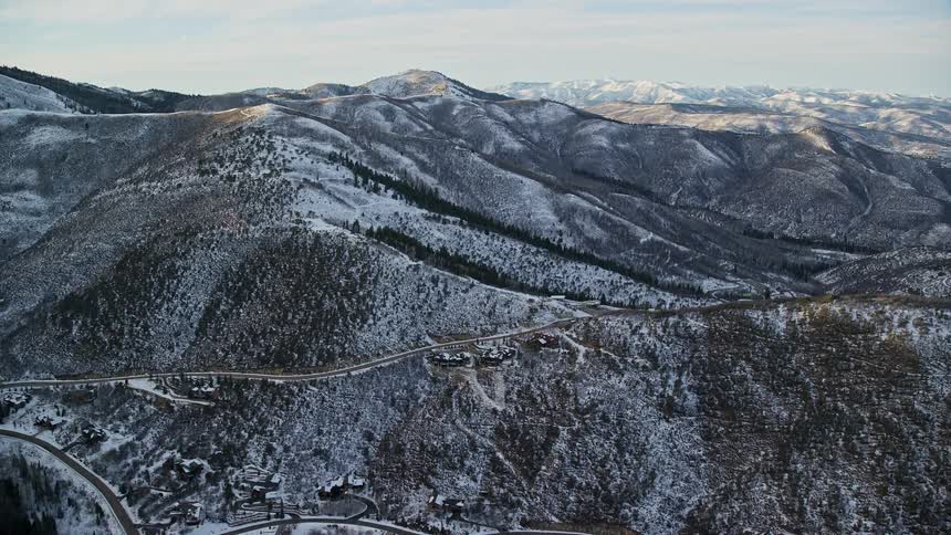 Aerial panorama of a mountain range with conifers covered in snow