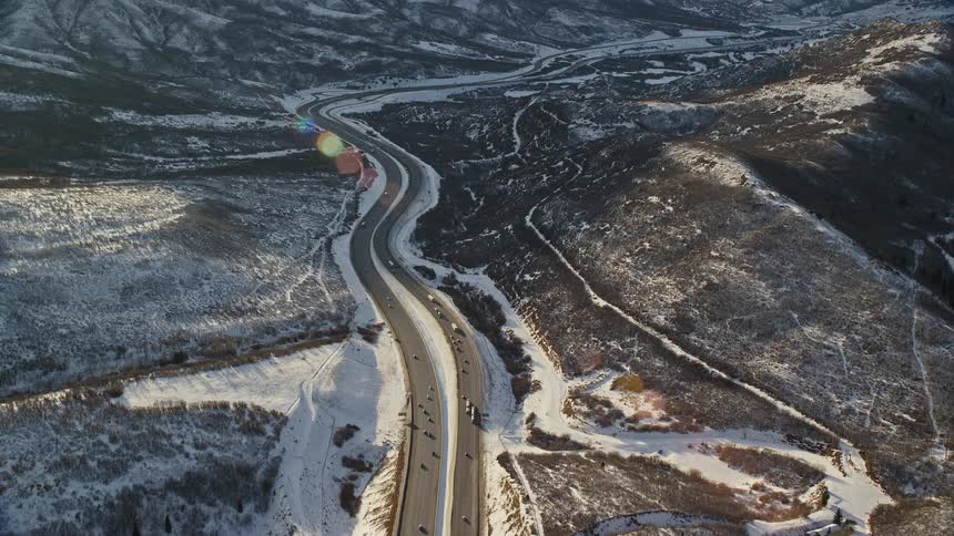 Aerial of a highway with calm traffic in the hills landscape during winter