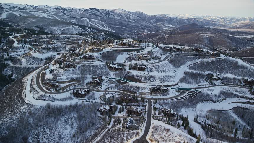 A small rural town with a few houses on top of a snowcovered hill on the ground