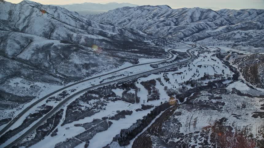 Highway winds through valley between mountains on a winter day