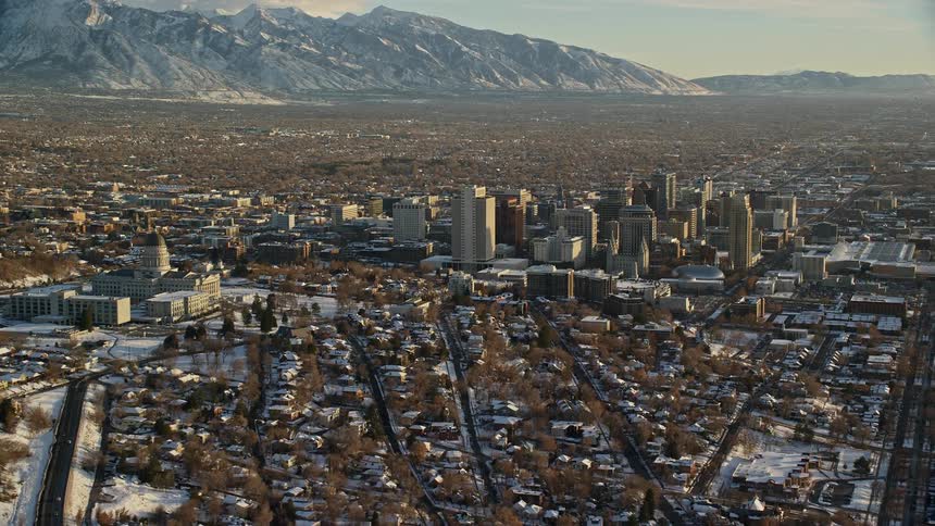 Panorama of a metropolis covered in snow with a chain of mountains on the horizon under a morning sky