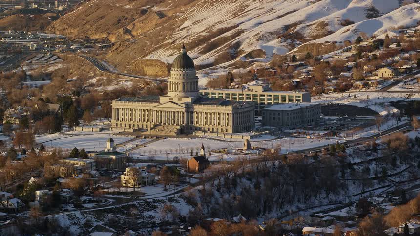 Aerial panorama of a parliament building in the midst of an urban city and facing a mountain