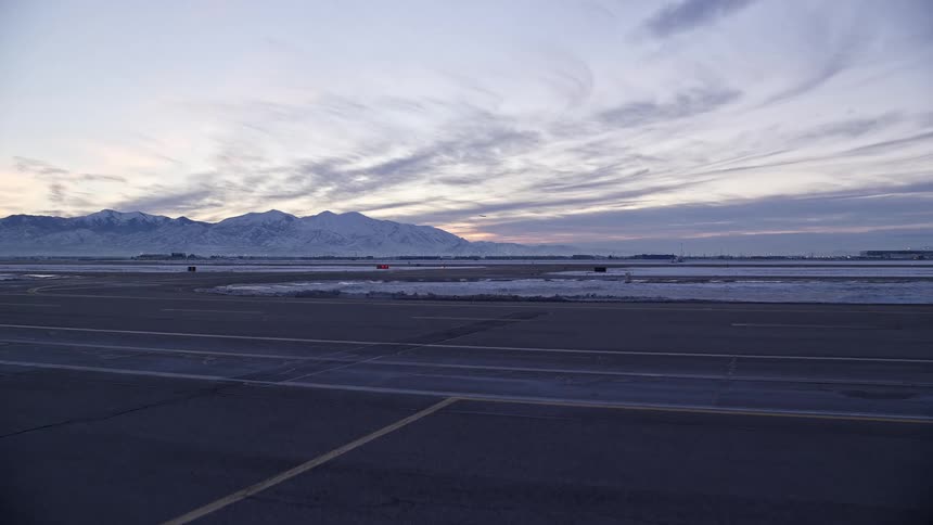 Aerial of an airport runway in the landscape with glacial mountains