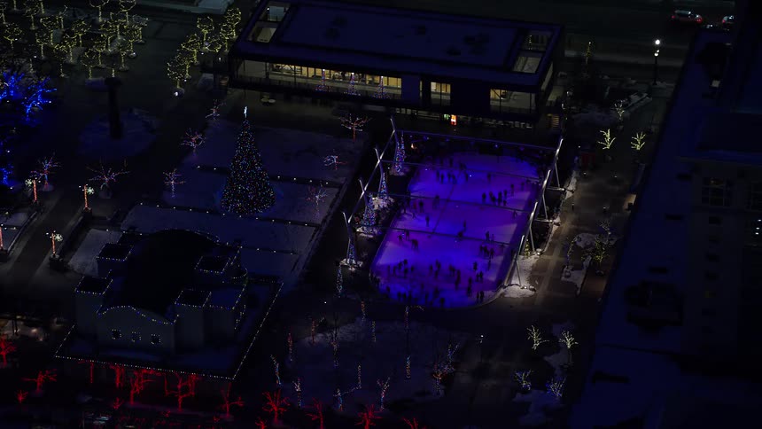 People are ice skating at night in the city
