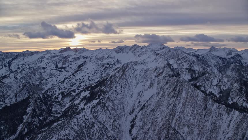 Aerial of frozen mountain range during sunset