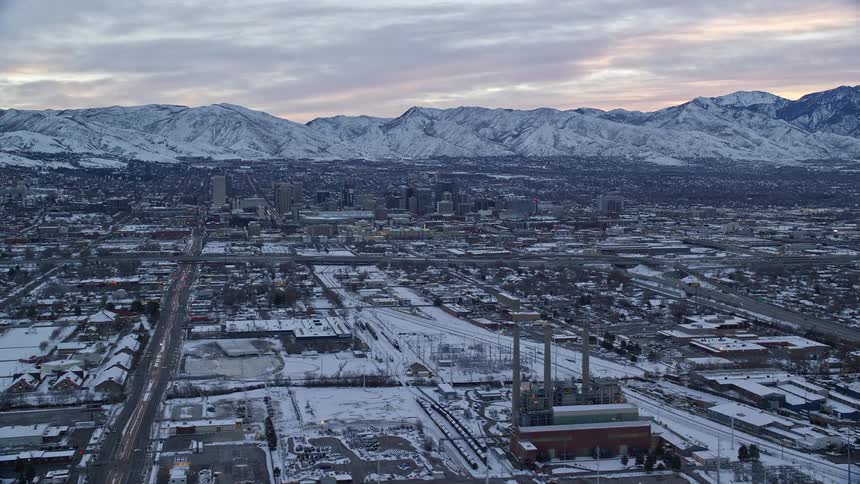 Aerial view of snowy cityscape and distant mountains in the background