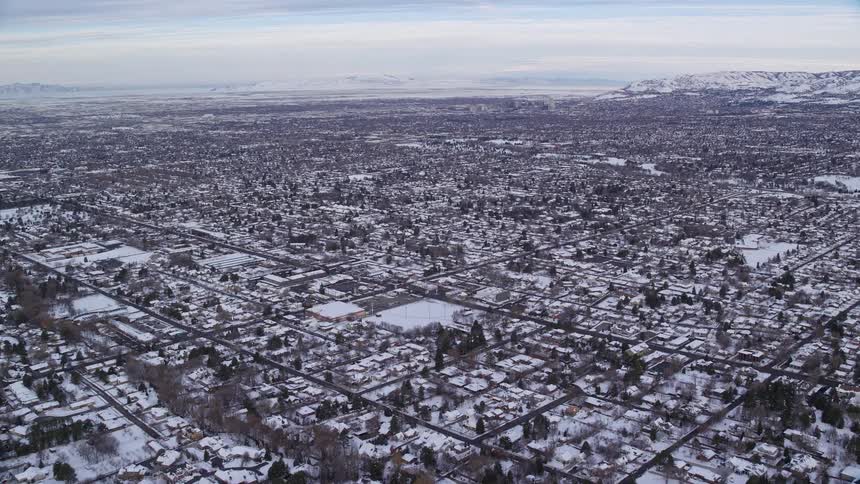 Neighborhood of a city with several houses and small buildings covered in snow during winter