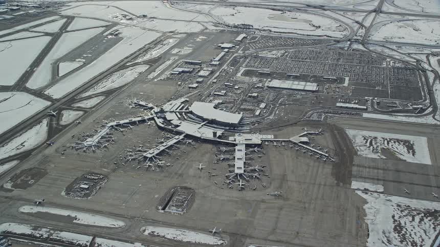 Aerial panorama of a snowcovered airport with moving airplanes