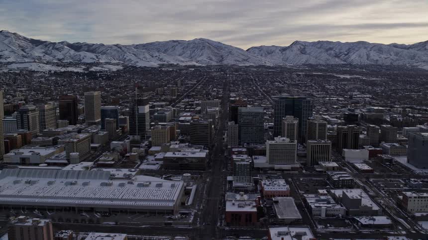Aerial panorama of a snowcovered metropolis surrounded by mountains in the morning