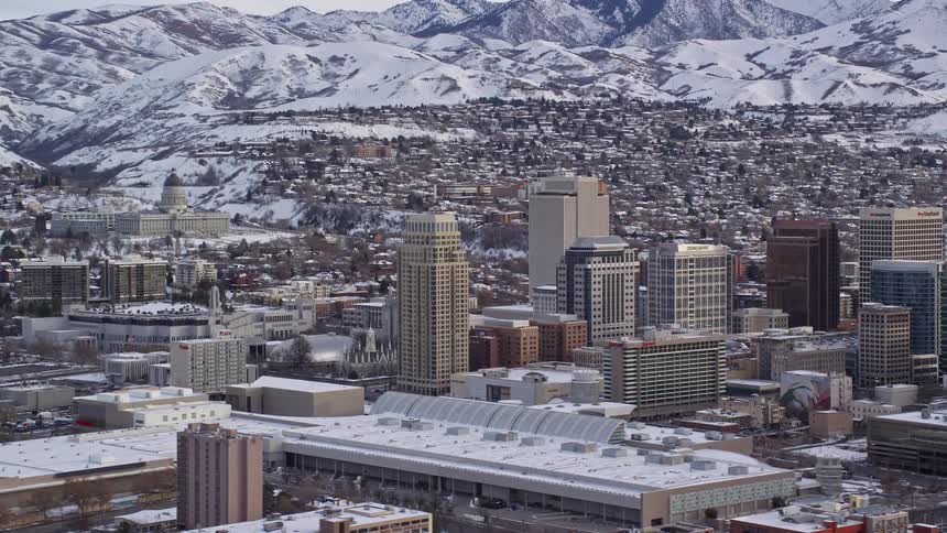 Aerial view of snowy downtown area in the city with distant mountains in the background