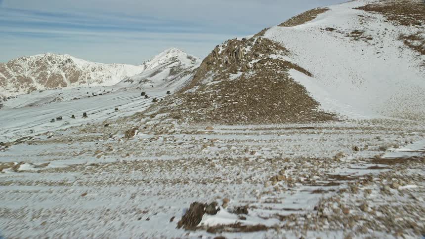 Panorama of a mountain range covered in snow on a cloudy day