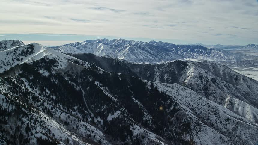 Aerial view of a snowcovered mountain range on a sunny day