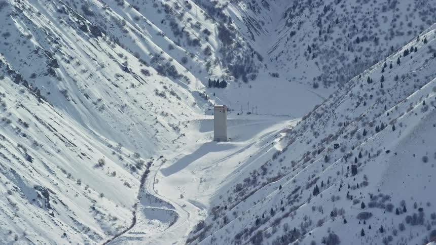 Aerial view of snowcovered mountains with a building in between
