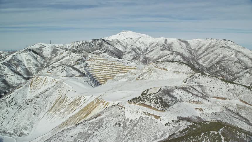 Panorama of a mountain range covered in snow on a cloudy day