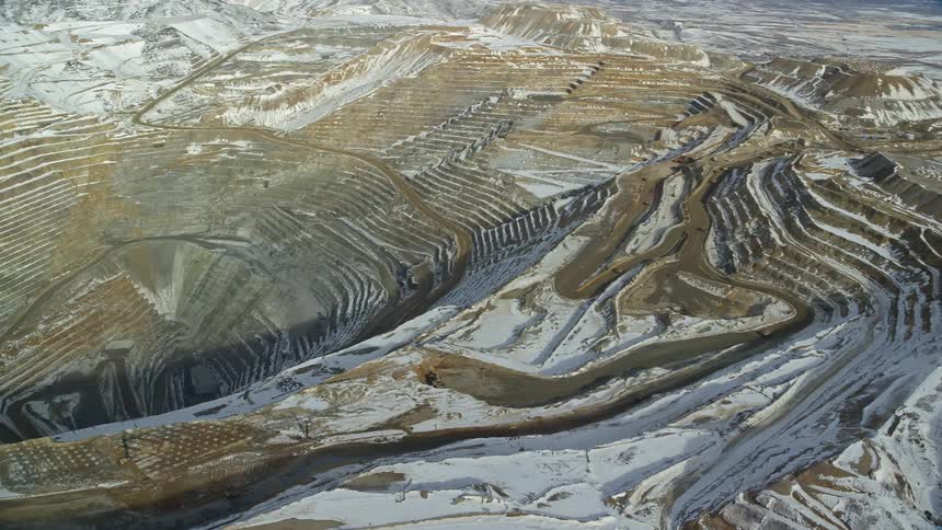 Aerial view of a quarry hole amid stone extraction mountains
