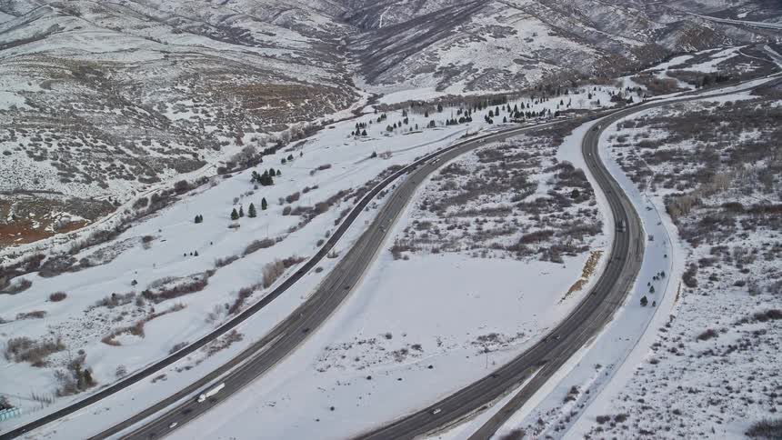 Aerial view of roads with vehicles passing through snowcovered mountains