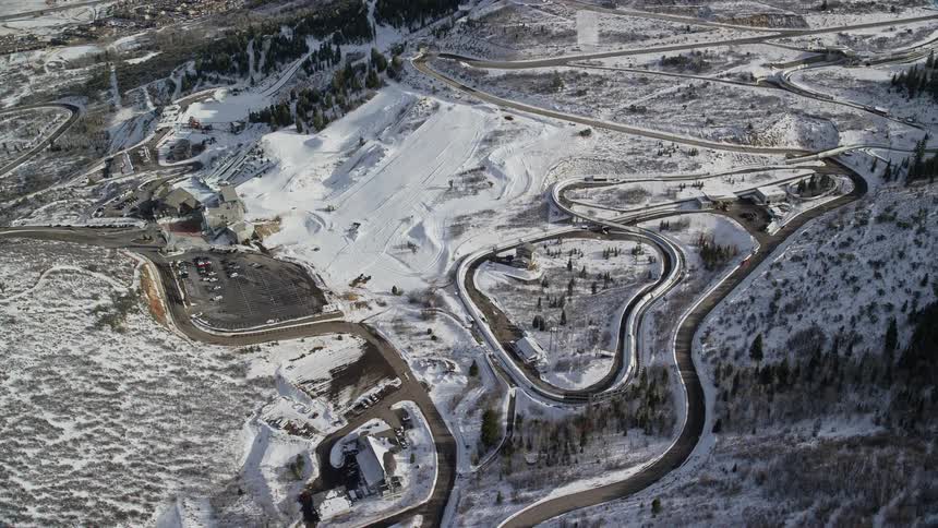 A very curvy roadway allows passage up a snow covered hill