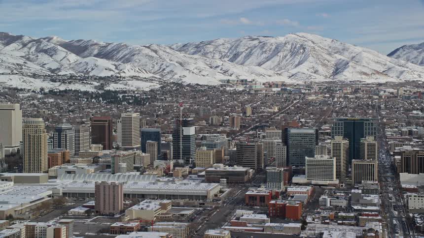 Aerial view of a metropolis surrounded by a chain of snowcovered mountains