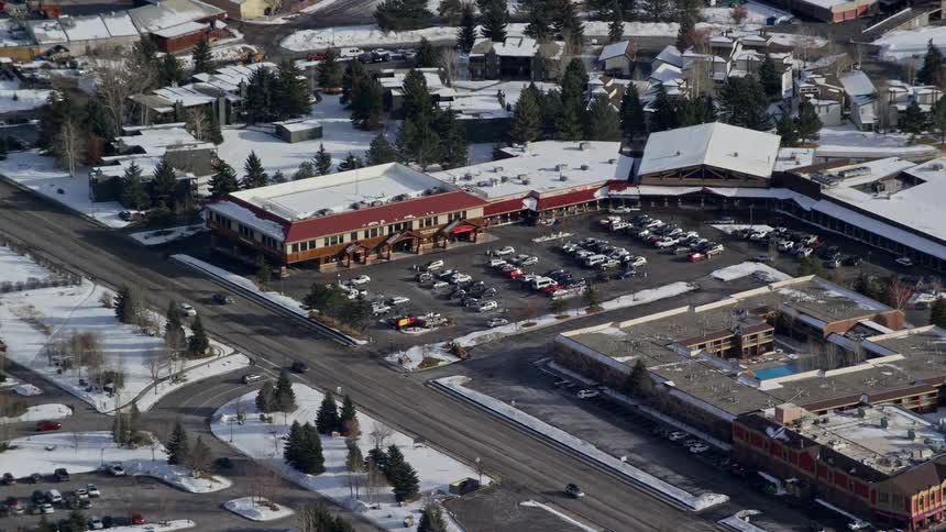 Aerial of a large establishment with parking in a neighborhood during the winter