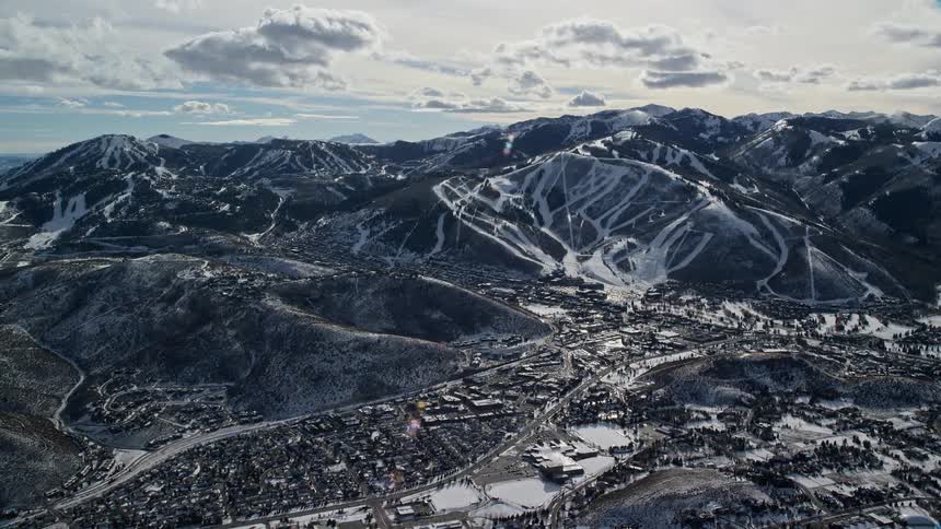 Aerial panorama of an urban city next to a range of mountains covered in snow