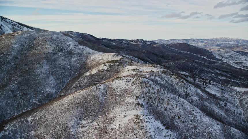 Aerial of valley surrounded by hills and mountains during winter