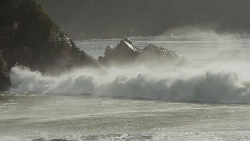Sea waves hitting the rocks and the coast during a late afternoon