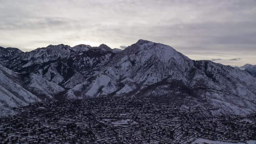 An aerial view of a rural town nestled between winter snowcovered mountains