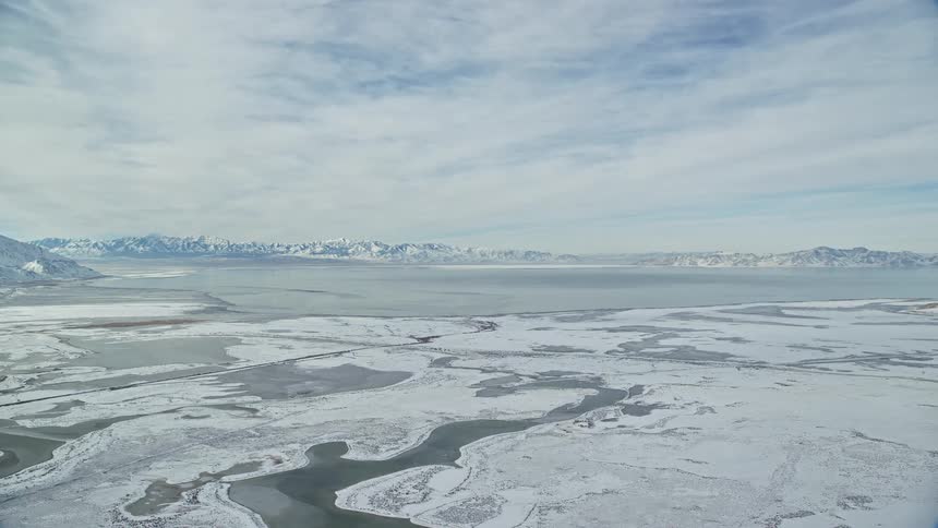 A landscape of a snowy region and snowcapped mountains
