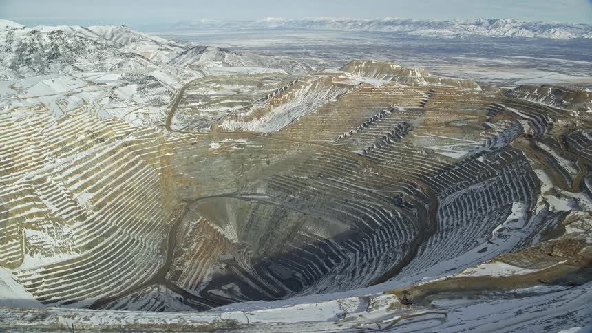 Rocky extraction mine crater with areas of snow