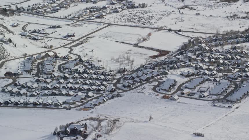 Rural suburban neighborhood surrounded by flat land all covered in snow on a bright day