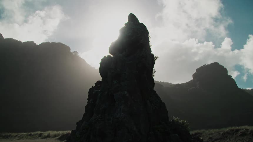 Rocky peak amidst a hilly coastline in the morning sunlight