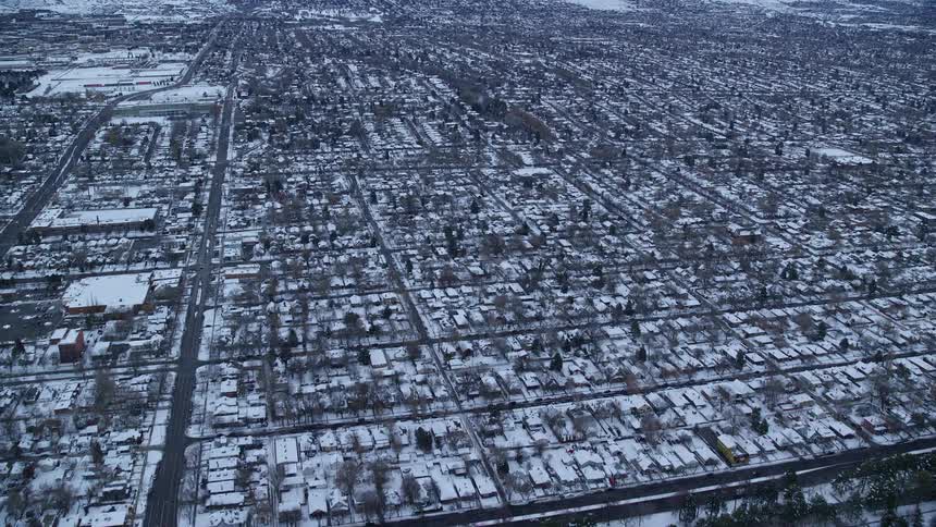 Aerial of residential homes in city neighborhoods with snow on the ground on a dreary morning