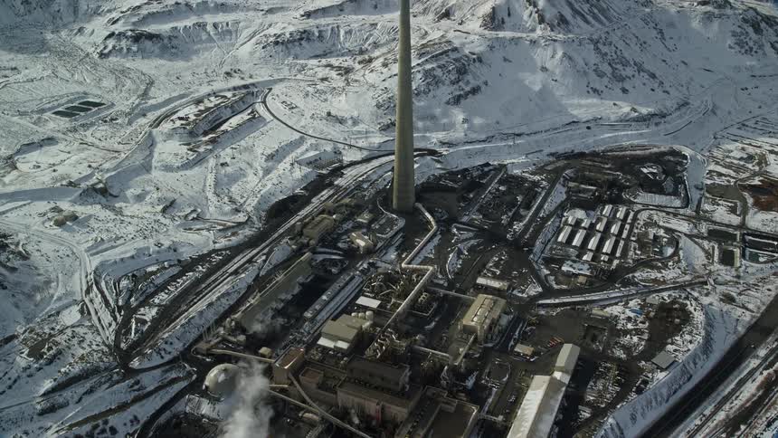 Aerial view of a factory next to snowcovered mountains