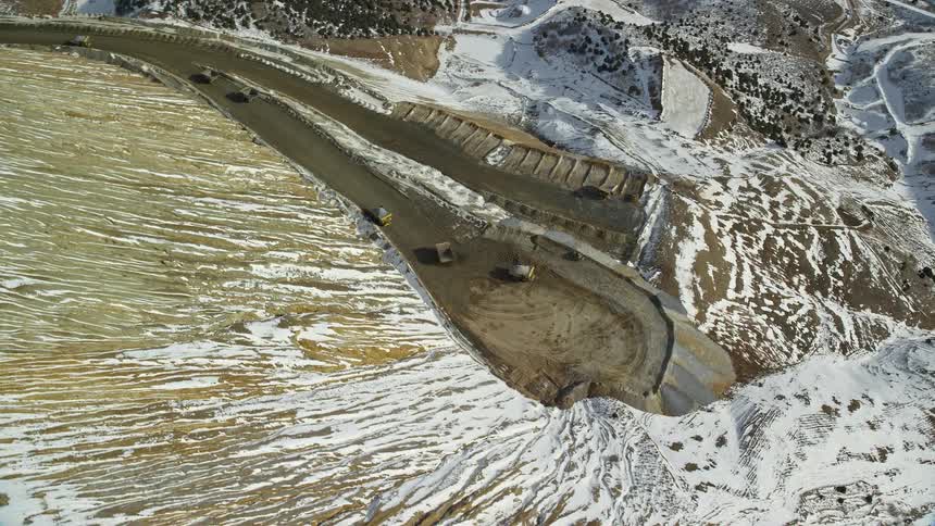 Aerial of mining trucks on a mountain transporting ore