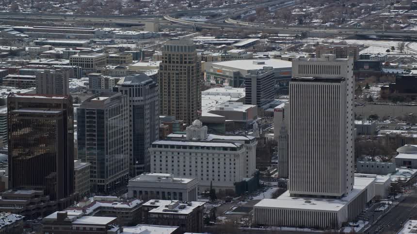 A city with tall buildings has snow on the ground