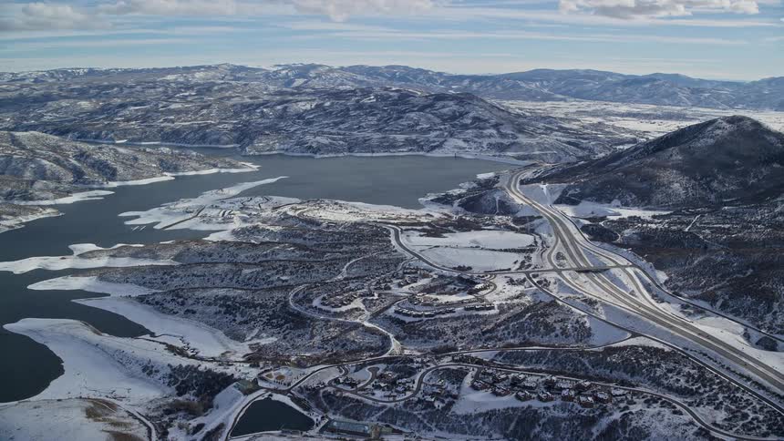 An aerial view of a region with roads and lakes in a snowy climate