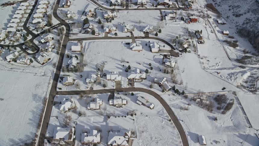 Aerial of a small neighborhood with houses covered in snow during winter