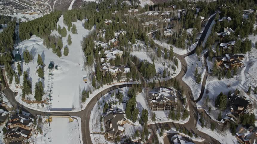Roads wind through forested residential neighborhood occupying hilly terrain