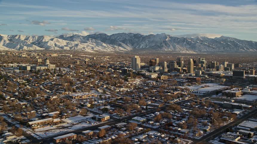 Aerial view of a snowcovered metropolis surrounded by mountains on the horizon in the morning